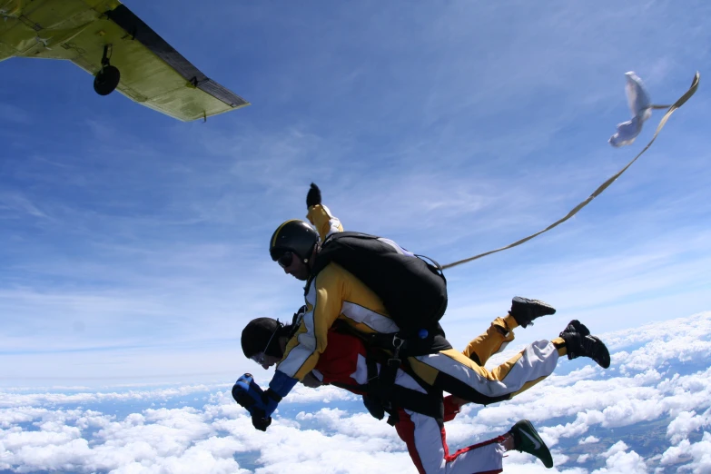 man in yellow jacket holding onto the back of an airplane