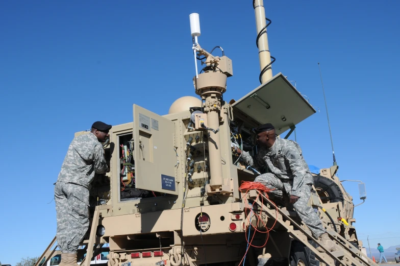 the soldiers are working on the military vehicle