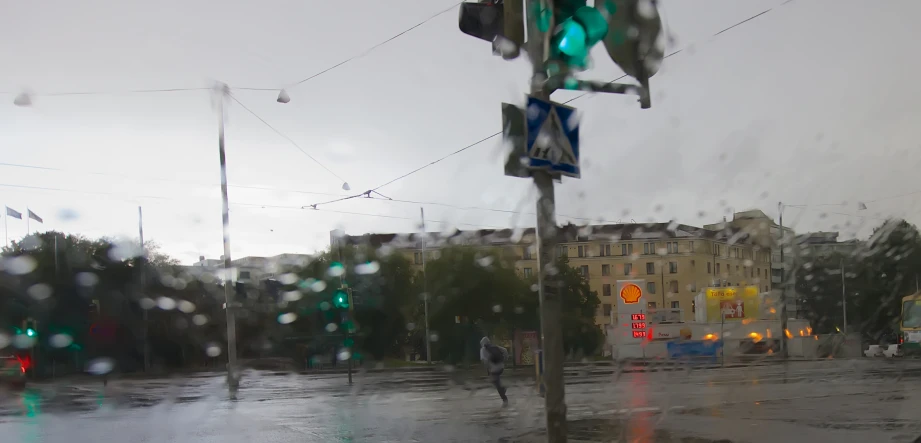 the traffic lights on a rainy day, and people standing in the rain