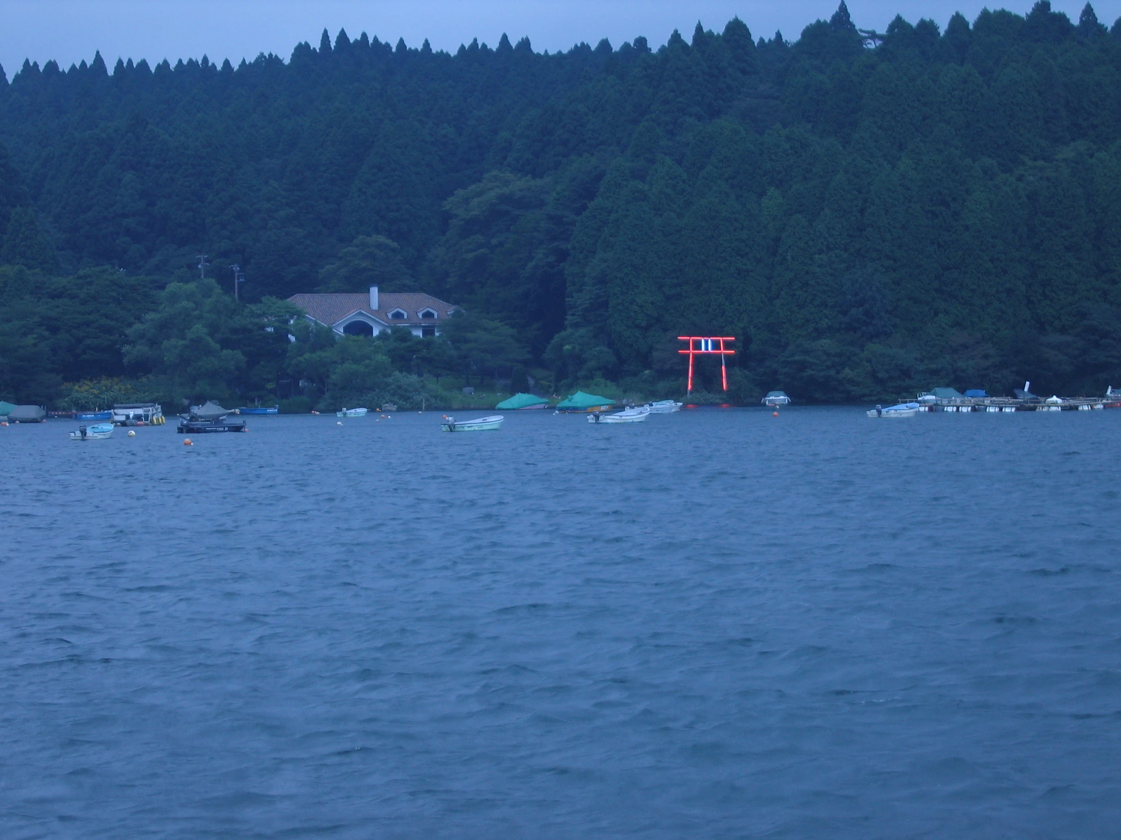 a house sits on an island off the side of a lake