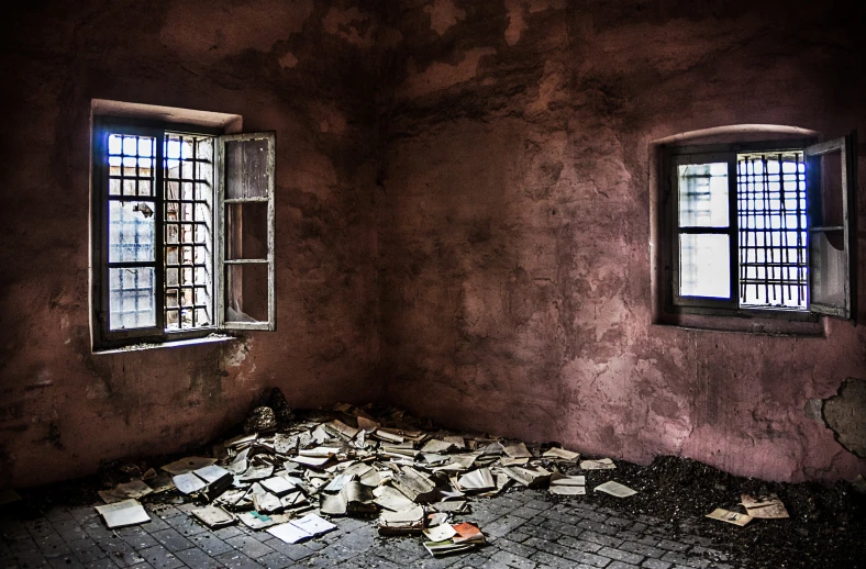 two windows and broken newspaper all in an old room