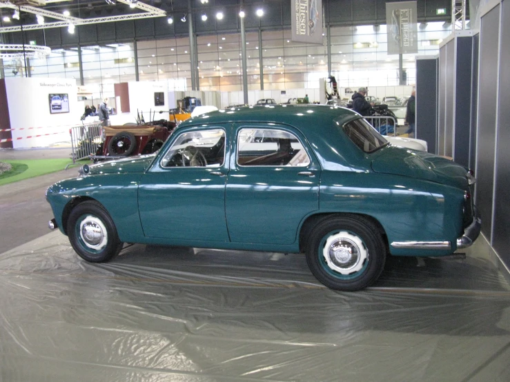 an old blue car is on display with lots of lights