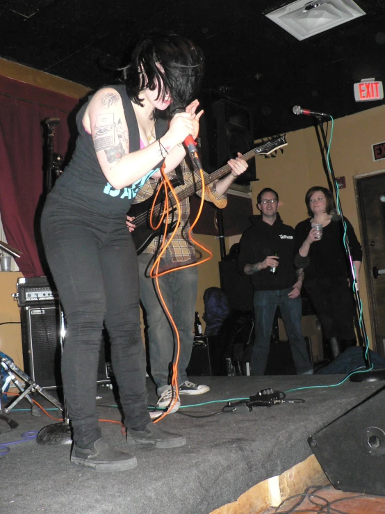 a woman standing on a stage with a guitar