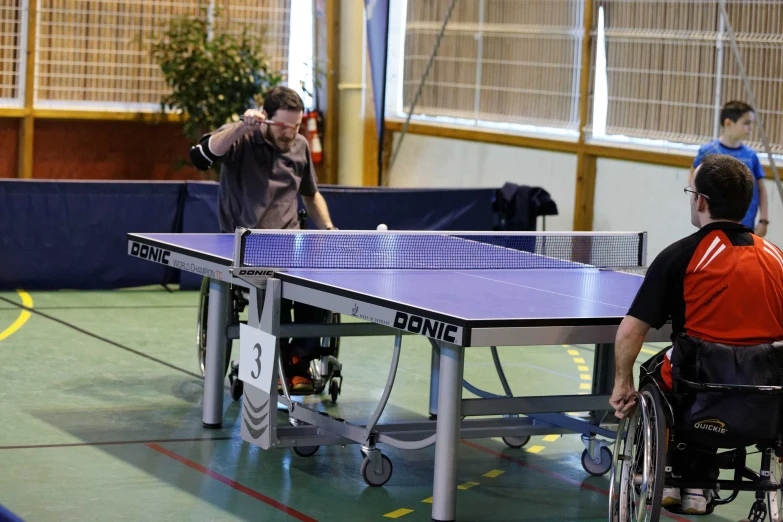 two men play ping pong on a tennis court