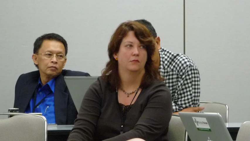 two people sitting side by side at a conference