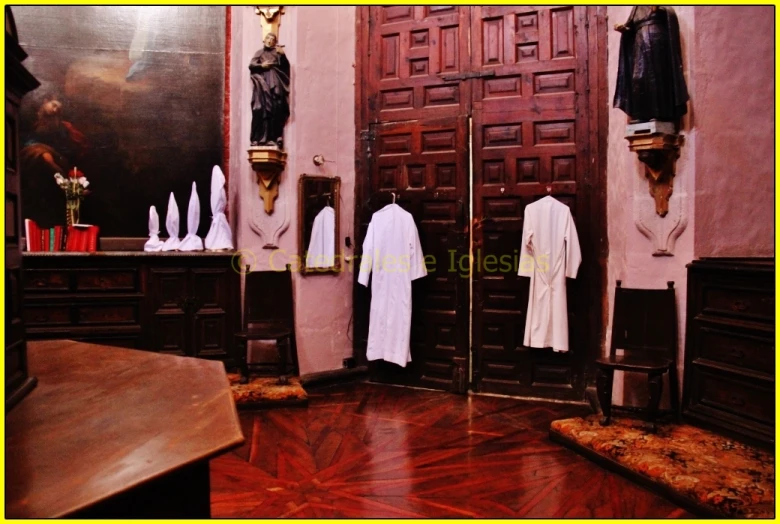 a room with two hanging robes on the wall