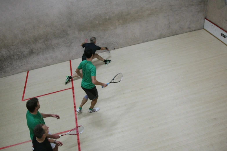 three people are in an indoor playing court