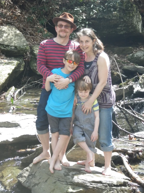 a family standing on rocks in the river