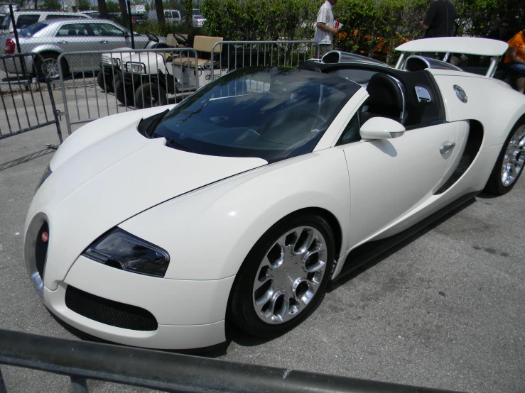 white car parked in parking lot near fence