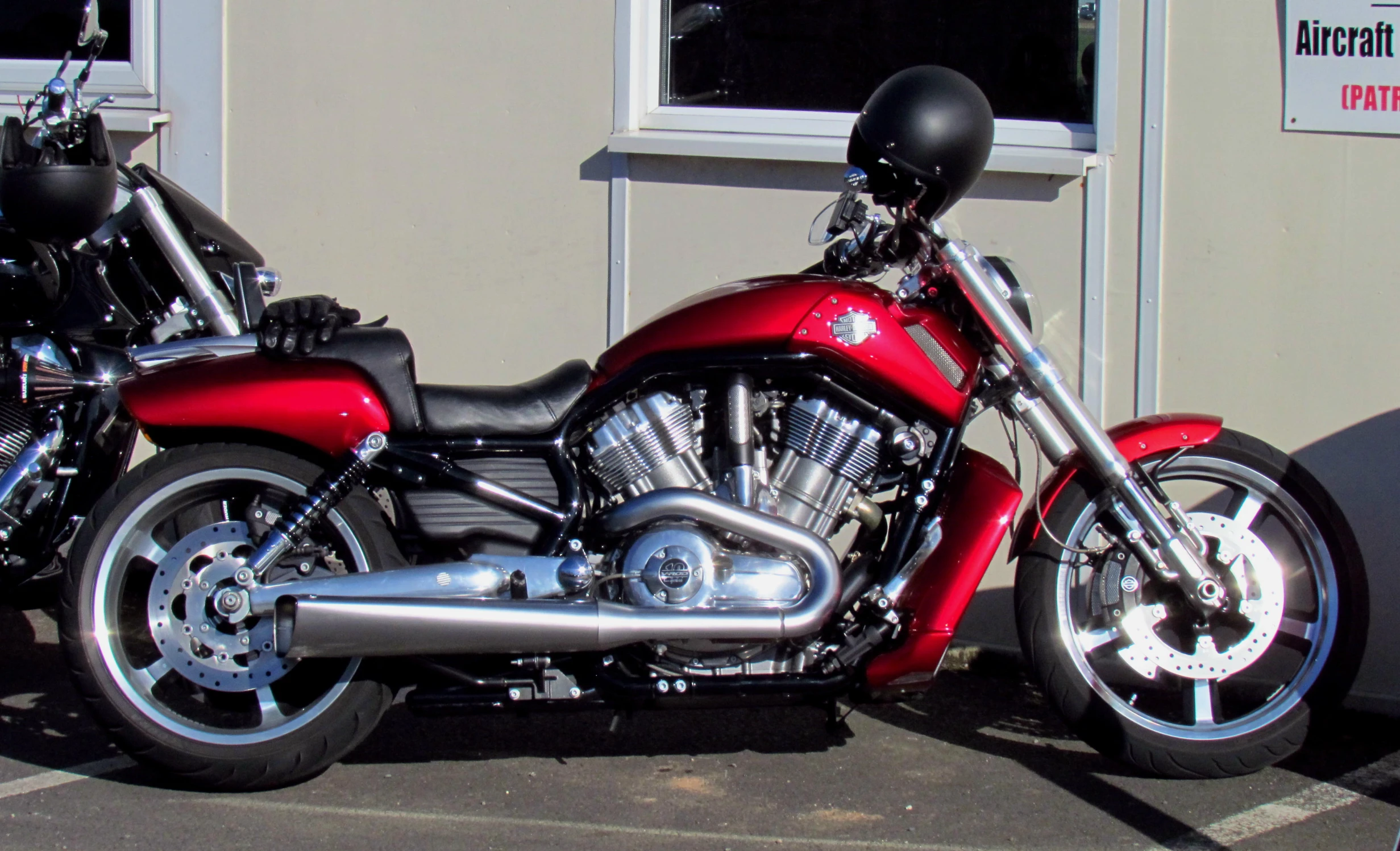 a red motorcycle parked in front of a business