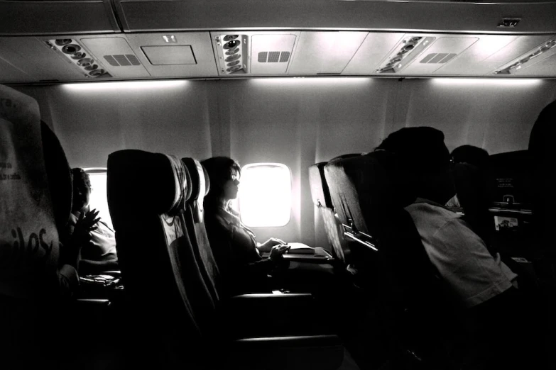 people on a plane sitting and looking at the screen