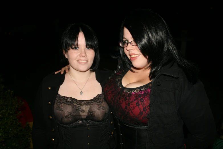 two females posing for the camera with one wearing a black shirt