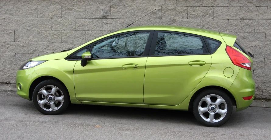 a small neon green, compact vehicle parked on pavement