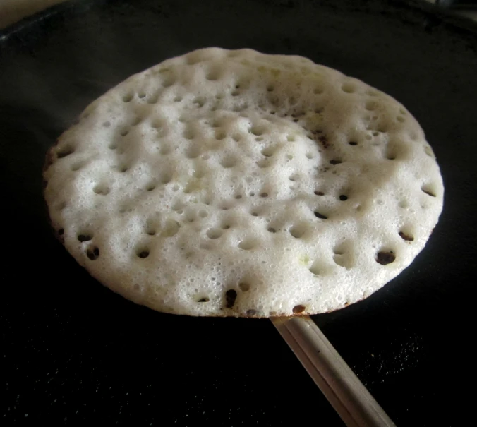 a white er on a stick with dark black spots