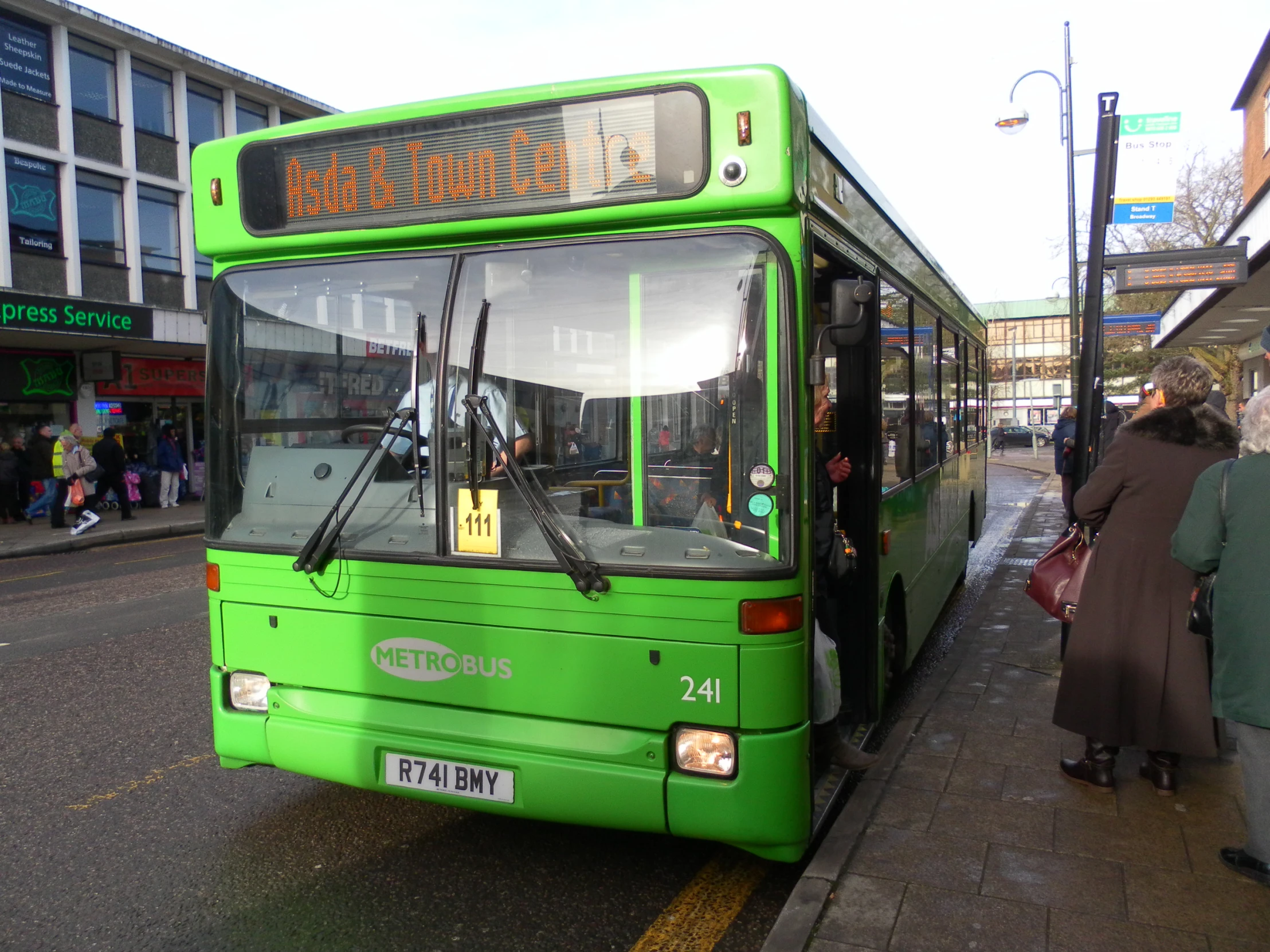 a green bus parked on the side of the road