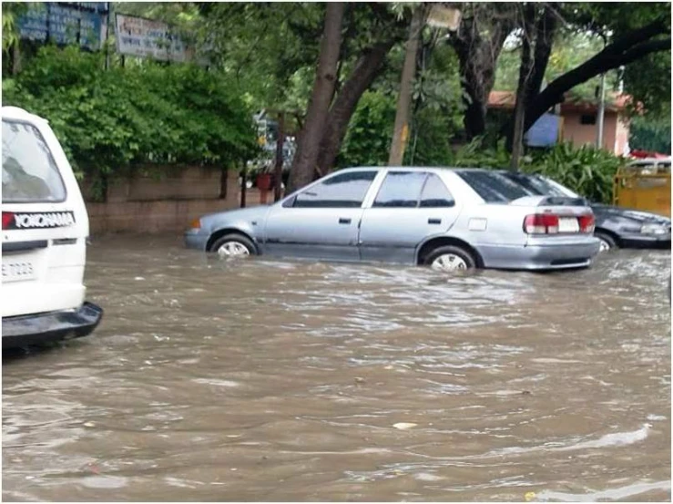 several cars stuck in water that is going under a street