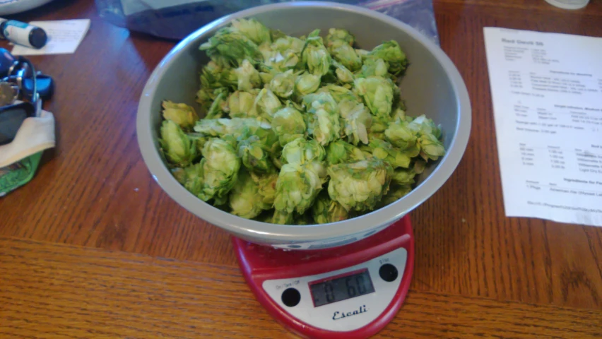 a bowl of green vegetables on top of a red scale