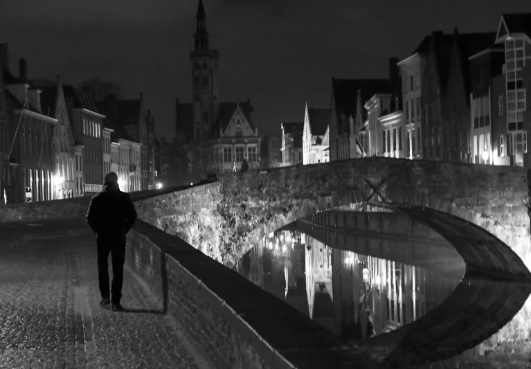 a man stands on the stone bridge in an old town