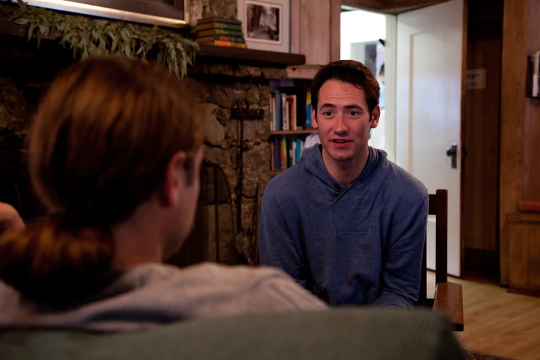 a man sitting and talking with another person