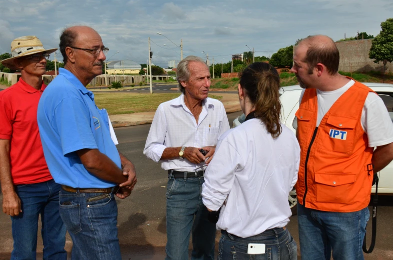 four people standing in a group while wearing safety vests