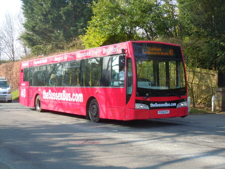 a large red bus sits in a lot