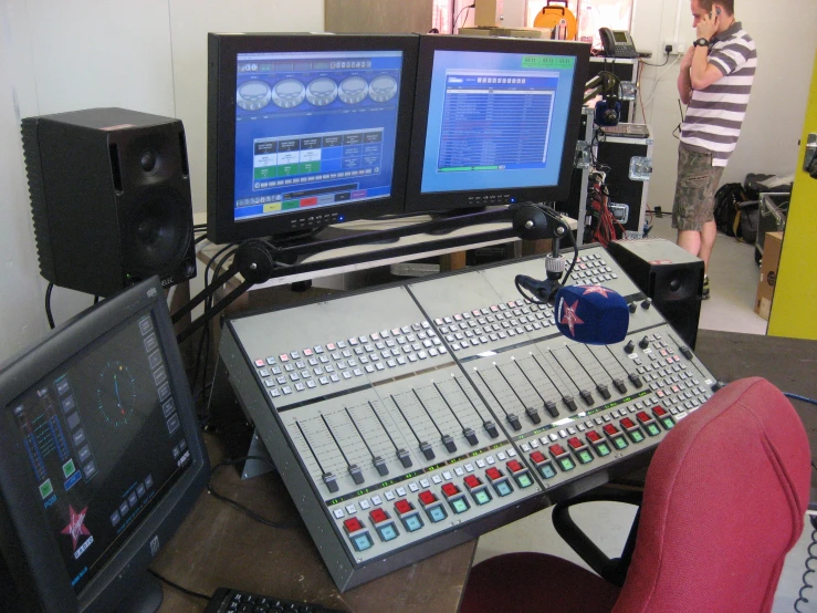 a music studio with two television screens and sound equipment