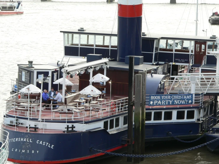 a boat with a few people on it is sitting at the dock