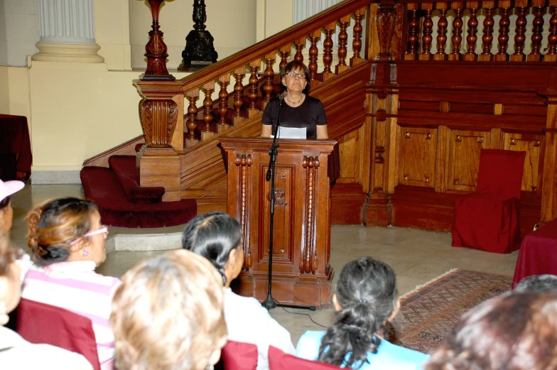 a man is speaking from a podium during a worship service