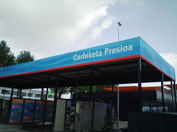 an empty gas station with a blue cover over the fuel tank