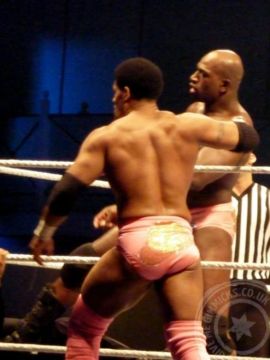 two wrestlers standing on a stage next to each other