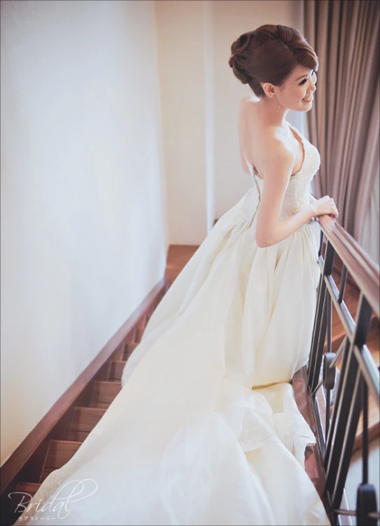 a woman in a wedding dress standing on some stairs