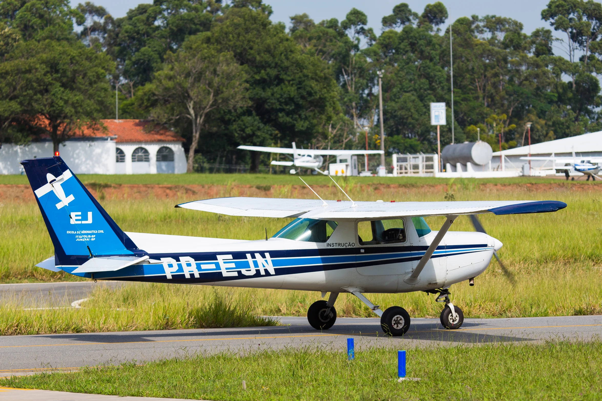 a small blue and white plane parked on a runway