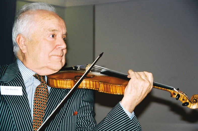 a man holding onto a violin with a on up jacket