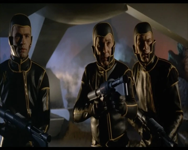 three actors stand in front of a gun in a sci - fi film