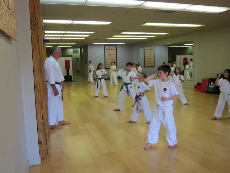 some guys standing in the middle of a large room with white robes