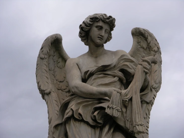 the statue has angel wings, and is holding a sword