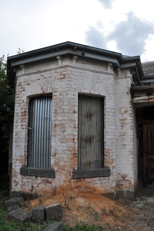 an old brick building with two windows and one door