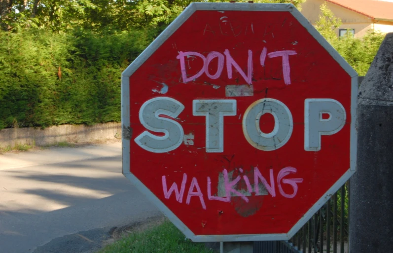 a stop sign with graffiti on it reads, don't stop walking