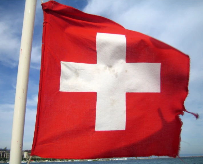 a red and white flag on the side of a boat