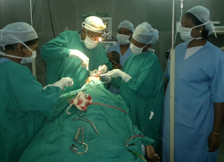 a group of doctors perform an operation on a man in the operating room