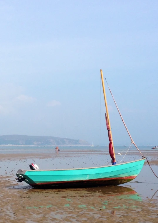 a small sailboat sitting on top of a beach