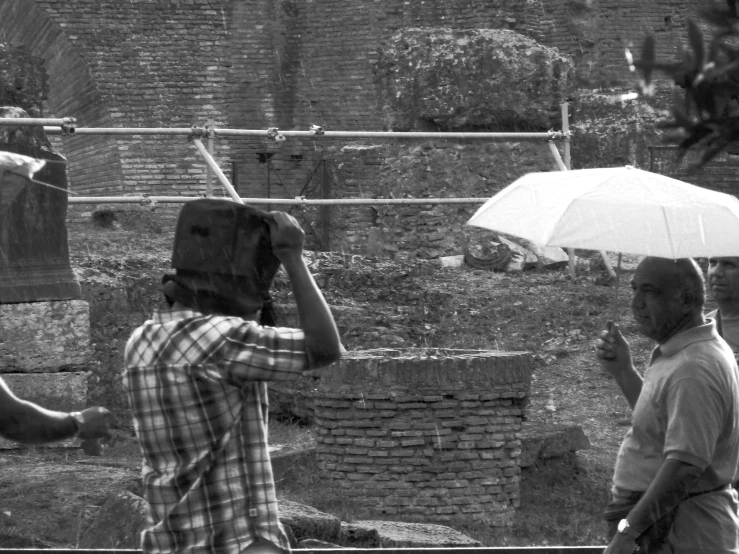 a man with a white umbrella standing next to other people