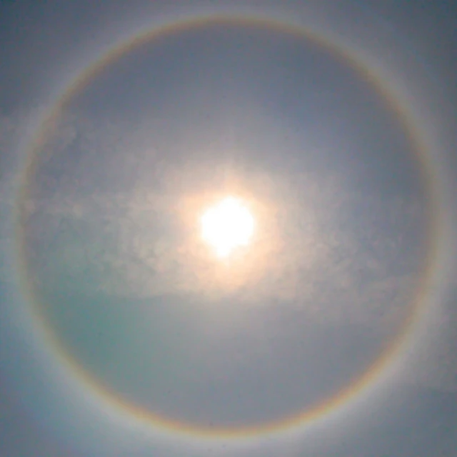 a sun halo seen against a blue sky with a circle