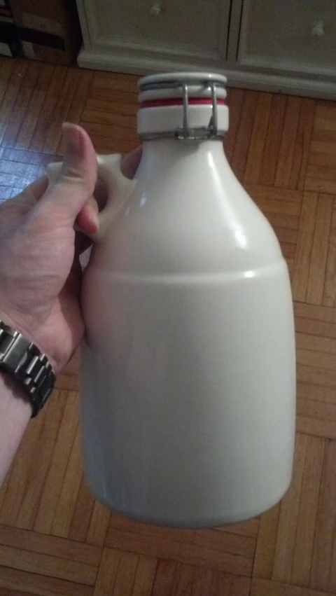 a large white jug being held in hand