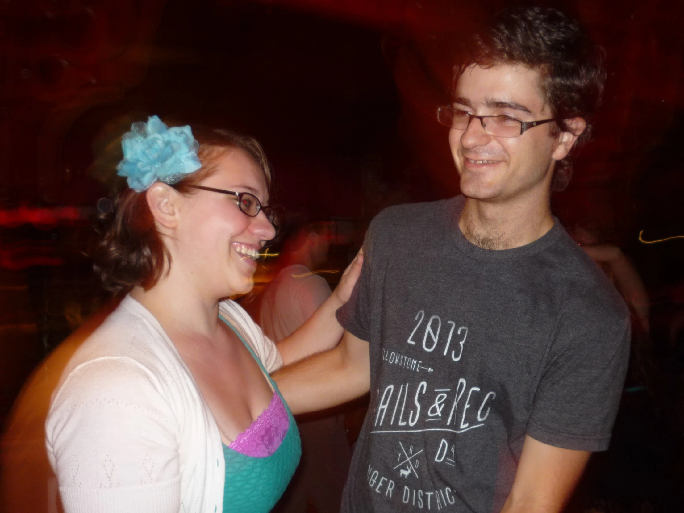 the man is touching the woman's hand as she laughs