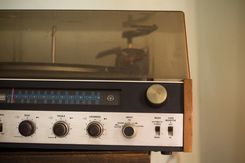 an old radio set sits in front of a white wall