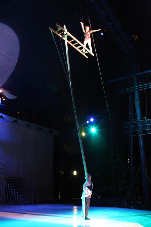 a woman is suspended on a pole with two lights