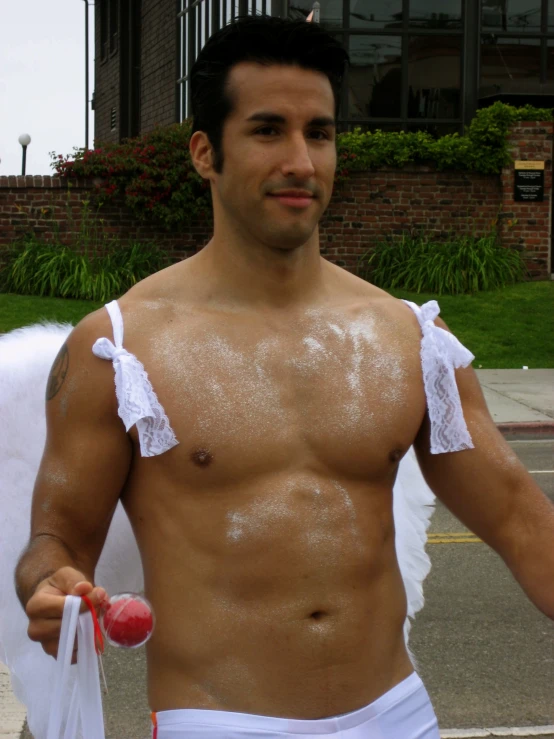 man in brief pants covered in white paint with a cloth around his chest and a small ball on his right hand