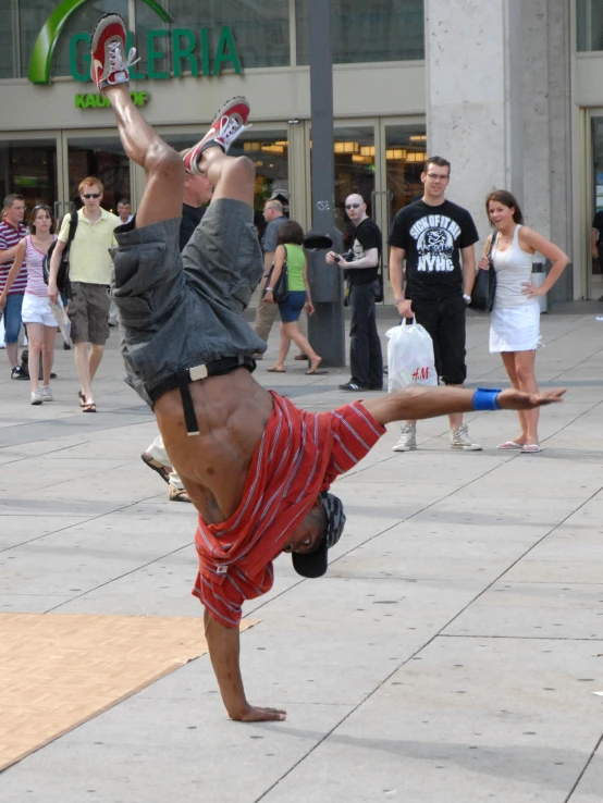 the young man in shorts is doing handstands