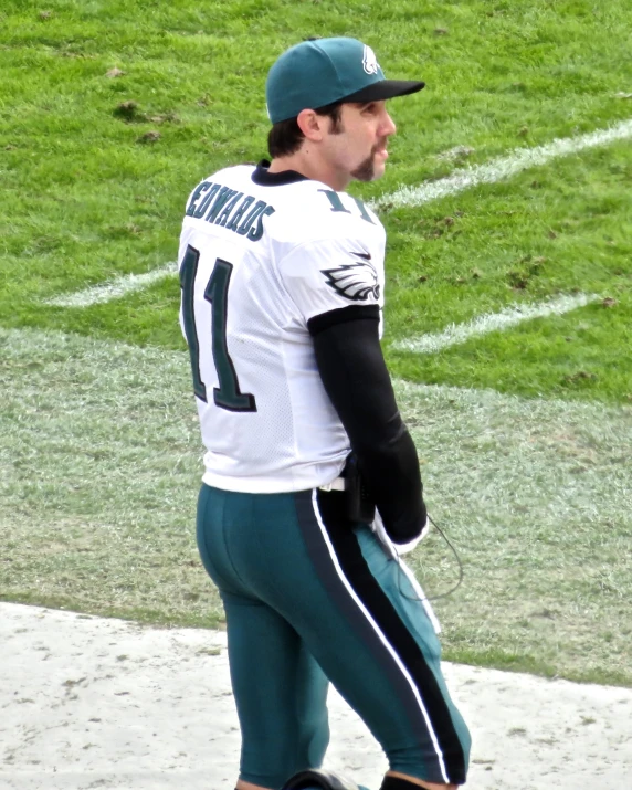 a football player walks on the side of the field